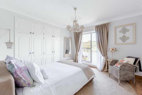 加亚新城Quinta da Agraceira Casa do Caseiro的白色的卧室设有一张大床和一个窗户