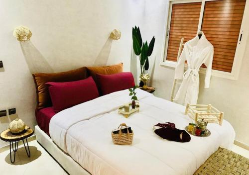 马拉喀什COSY LUXURY Apartment - GUELIZ的卧室配有带红色枕头的大型白色床