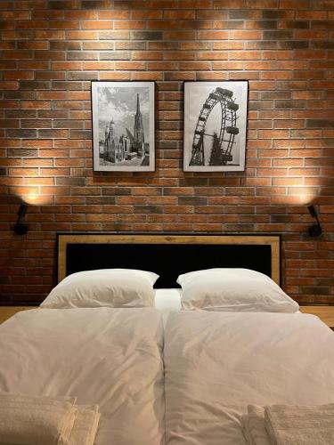 维也纳Donau Apartment Vienna的一间卧室设有两张床和砖墙