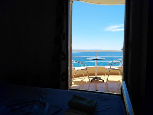 希马拉Magic Ionian Apartments & Rooms的卧室设有海景阳台。