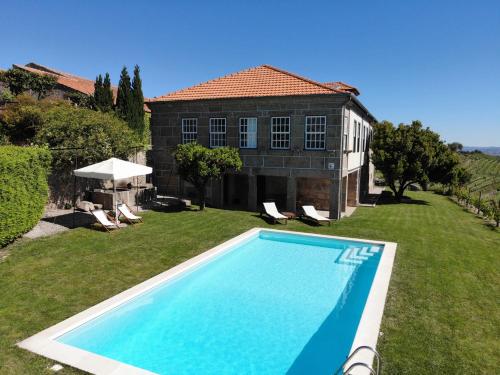 拉梅戈Quinta da Portela - Casa Visconde Arneiros的一座房子的院子内的游泳池