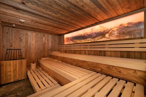 埃布斯dasKAISER - Dein Gartenhotel in Tirol的空的桑拿,有木凳和绘画