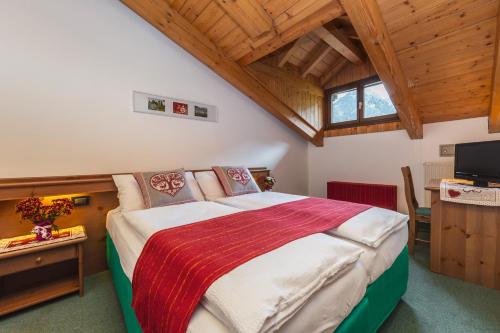 兰佐莫蒂坎塞Cadria Nature & Bike Hotel的一间带一张大床的卧室,位于一个拥有木制天花板的房间
