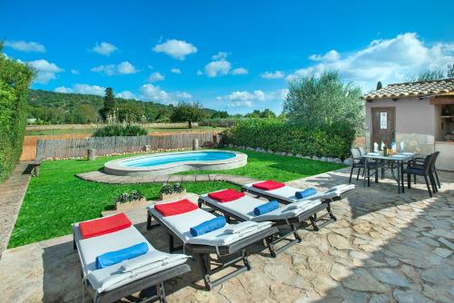 坎帕内特Owl Booking Villa Garreta - Rustic Stay with Mountain Views的一个带桌椅的庭院和一个游泳池