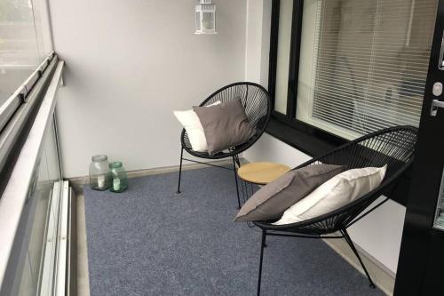 伦派莱MODERNI YKSIÖ HUIPPUSIJAINNILLA!的带窗户的客房内配有两张带枕头的椅子