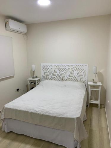 圣米格尔·德·图库玛Monoambiente Plaza Belgrano的卧室配有白色的床和2个床头柜