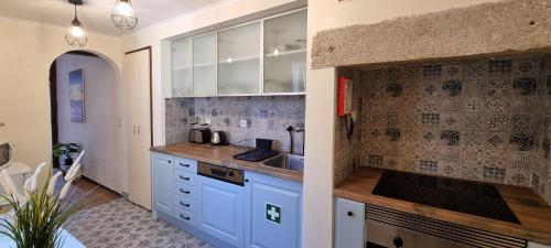 阿尔马达Casa do Alfaiate ® Home&Breakfast的厨房配有白色橱柜和水槽