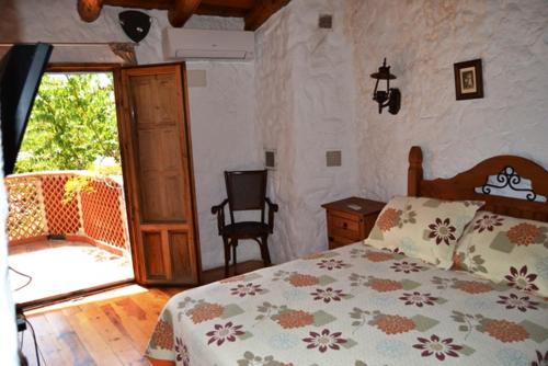 耶斯特Casas Rurales La Tejeruela的一间卧室设有一张床和一个滑动玻璃门