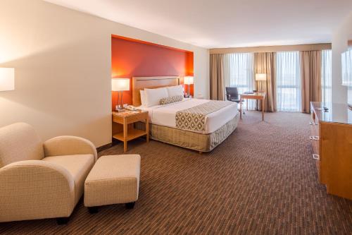 蒙特雷皇冠假日酒店蒙特雷机场酒店的大型酒店客房,配有床和椅子