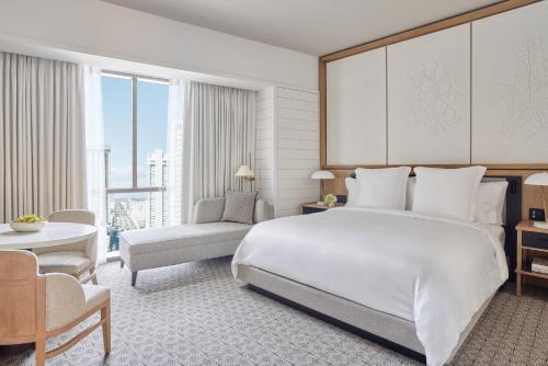 新奥尔良Four Seasons New Orleans的卧室配有一张白色大床和一把椅子