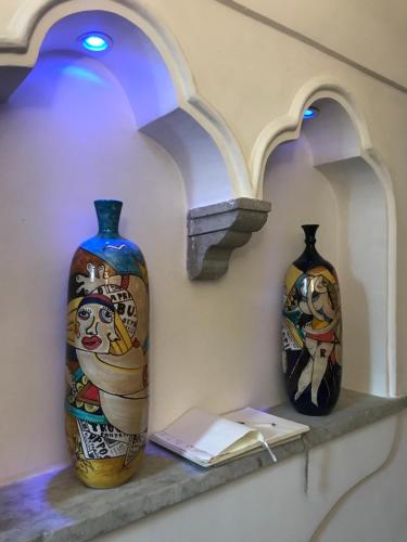 阿马尔菲克罗齐迪阿马尔菲酒店的两瓶花坐在墙上的架子上