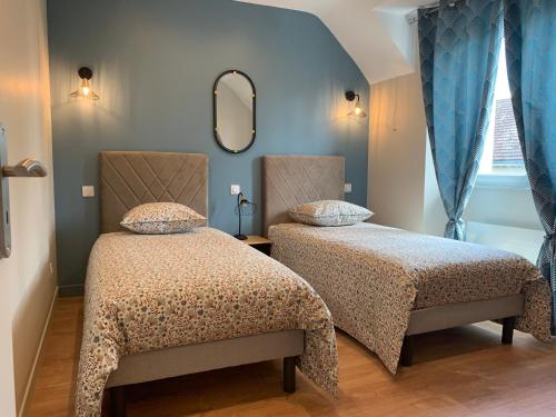 PontlevoyEntre Cher et Loire的一间卧室配有两张床和镜子