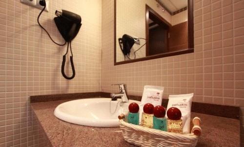 马德里阿维尼达巴拉哈斯酒店的一间带水槽和一篮樱桃的浴室