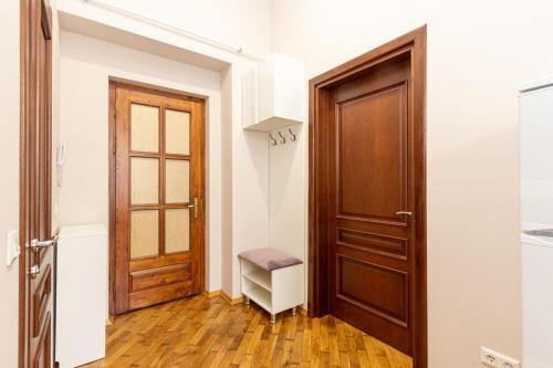 伊万诺-弗兰科夫斯克Апартаменти в центрі міста的走廊上设有木门和凳子