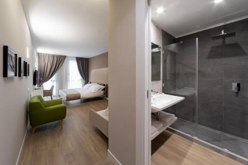 那不勒斯Alma Suites的带淋浴和盥洗盆的浴室以及一间卧室