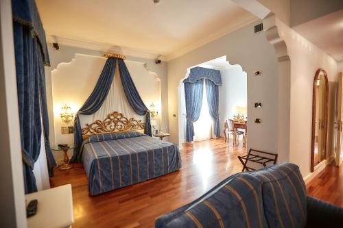 丘西Hotel Villa Il Patriarca的一间卧室设有一张床和一间客厅。