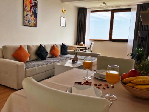 奥拉萨奇Sea View Suite的客厅配有沙发和带酒杯的桌子