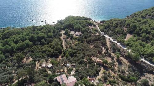 GâvurağılıLikya Inn - Dodurga&Patara Evleri的水边山丘上房屋的空中景观