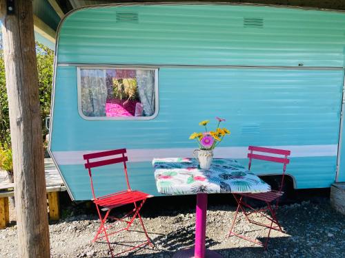 瓦伦西亚岛Retro Caravans at Valentia Island Escape的蓝色拖车旁的一张桌子和两把椅子