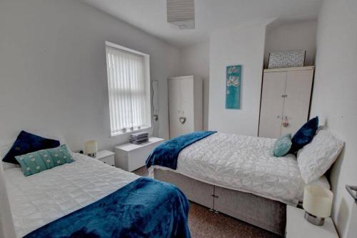 伯恩利Pomfret House, in Burnley Central, Ideal for Contractors with Free Parking and Wifi的一间卧室设有两张床和窗户。
