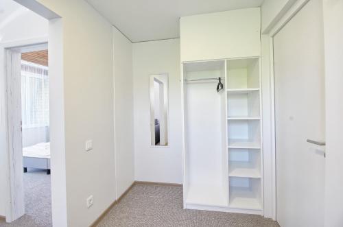 奈达Vila Kastytis的一间设有白色墙壁和一个带镜子的衣柜的房间