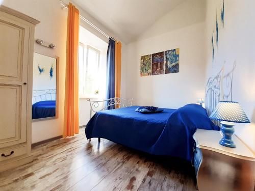 奇维塔韦基亚DIMORA IL CAMALEONTE, apartments in nature near the sea的一间卧室设有蓝色的床和窗户。