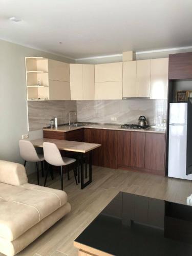 科布列季Maritas apartament的厨房配有桌子和白色冰箱。