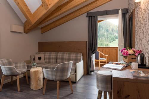 博萨迪法萨X Alp Hotel的客厅配有沙发、椅子和桌子