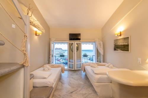 提诺斯Fratelli Rooms的客厅配有4张白色沙发和水槽