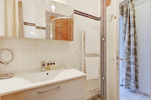 巴黎Suite junior avec balcon et vue sur Arc de Triomphe的白色的浴室设有水槽和镜子