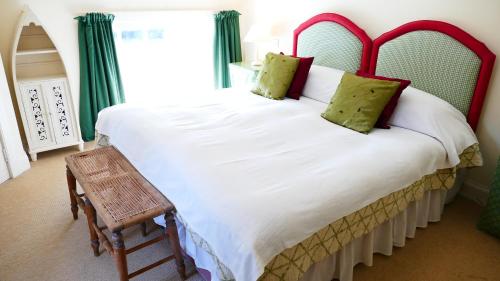 DollarArndean Cottages的卧室配有带绿色窗帘的大型白色床