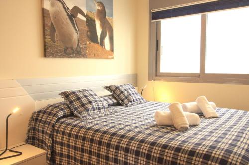 帕洛斯角Spanish Connection - Las Drizas的一间卧室配有一张带两个枕头和企鹅的床