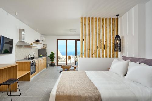 阿纳菲Casa Di Namphio Villa & Suites Anafi的一间带大床的卧室和一间厨房