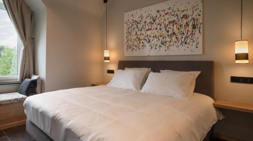 JodoigneLa Villa du Hautsart的卧室配有白色的床和墙上的绘画作品