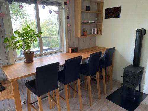 斯特伦斯塔德Stuga på Rossö, Strömstad的厨房配有木桌、椅子和炉灶