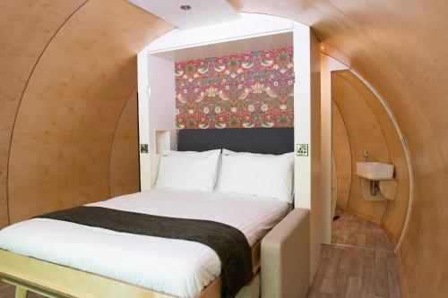 唐帕特里克Kinelarty Luxury Glamping Pods Downpatrick的一个小房间的一个床位,上面有拱门