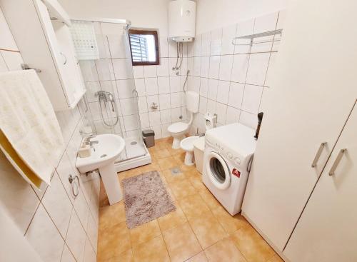 东兹斯托里弗Bay Terrace Apartment的浴室配有卫生间水槽和洗衣机。