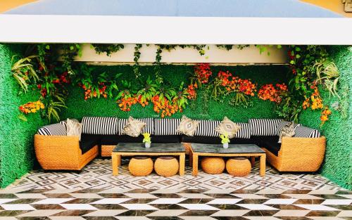 利雅德Riyadh Inn Hotel的天井配有沙发、桌子和鲜花