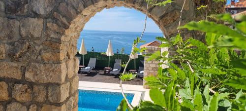 乌尔齐尼帕拉塔威尼斯酒店的石墙享有游泳池和大海的景致。