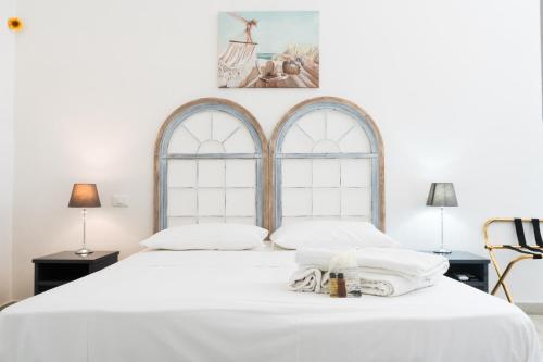 法维尼亚纳Poggiamico Guest House的卧室配有一张白色大床和两个窗户