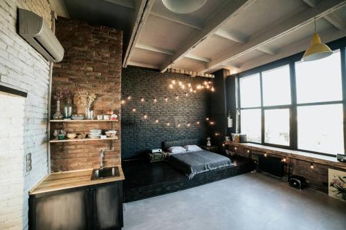 尼古拉耶夫Лофт студия с панорамной террасой的一间卧室设有一张床和砖墙
