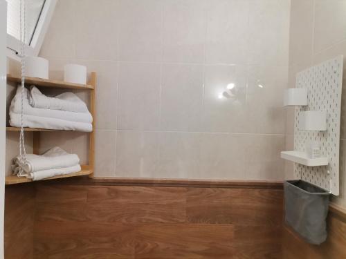 贝纳尔马德纳Apartamentos La Mar Chica的铺有木地板的浴室,配有白色毛巾。