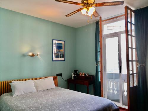 锡切斯Privat Hotel Liberty Sitges的一间卧室配有一张床和吊扇