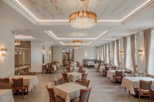 维尔纽斯潘塔德乌什酒店的一间带桌椅和吊灯的用餐室