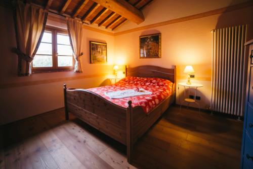 蒙特普齐亚诺Borgo 7 TigliAppartamento a Montepulciano n7的一间卧室配有一张带红色棉被的床和窗户。