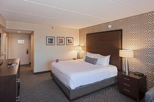 布卢明顿Crowne Plaza Suites MSP Airport的酒店客房设有一张大床和一张书桌。