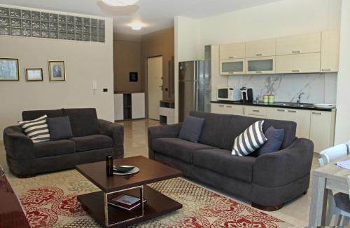 都拉斯Main square apartment的一间带两张沙发的客厅和一间厨房