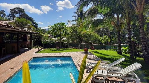伊利亚贝拉Moana Ilhabela的后院设有游泳池、椅子和树木
