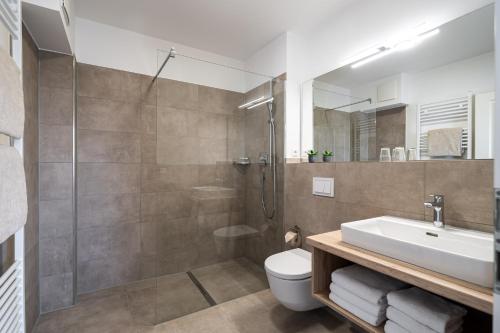 瓦尔内明德施特兰德哈弗公寓酒店的带淋浴、盥洗盆和卫生间的浴室