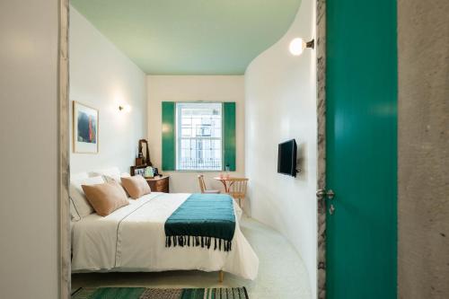 阿马兰特Covelo - The Original Rooms and Suites的一间卧室设有一张床和一个绿门